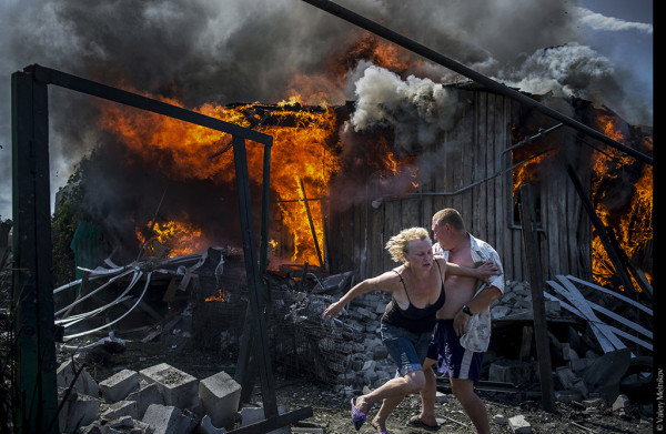  Uno sguardo sul mondo | VALERY MELNIKOV - Black Days of Ukraine. Civili in fuga dall’incendio di una casa distrutta da un attacco aereo nel villaggio di Luhanskaya. © Valery Melnikov 