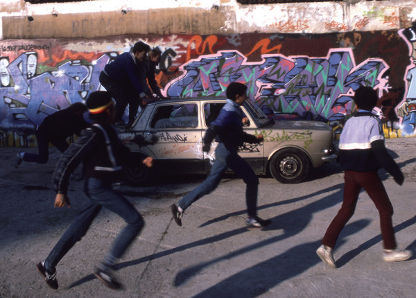 Henry Chalfant, Boys chase abandoned car past St…ll, Paris, 1985